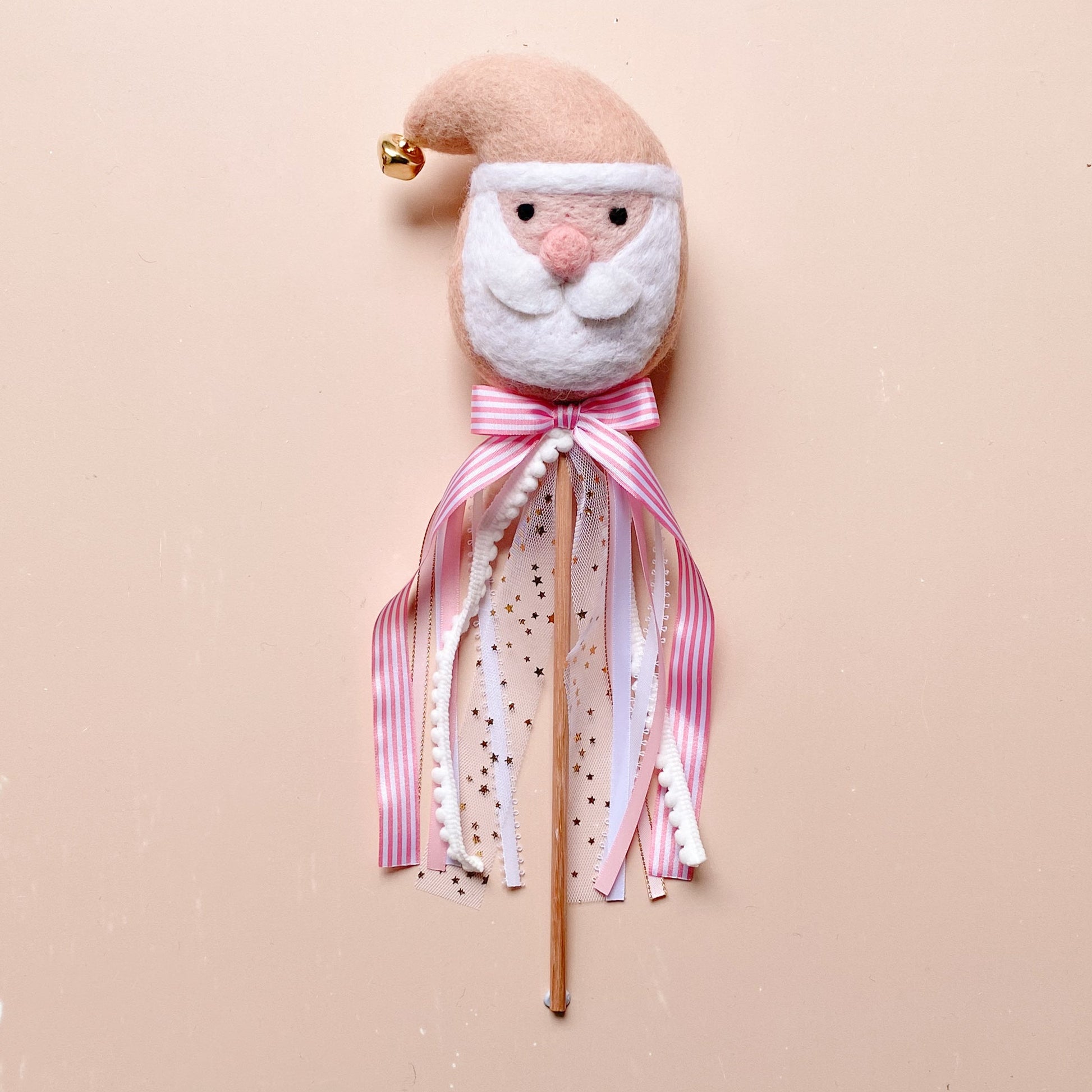 Decorative wand with a wool felted Santa face and pink ribbon 