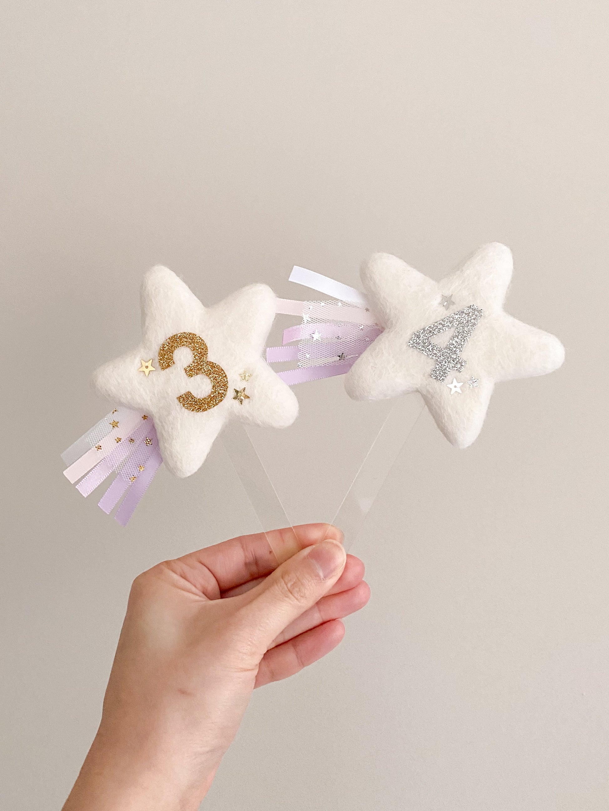 Star shaped cake topper with birthday age and ribbon streams and glitter stars 