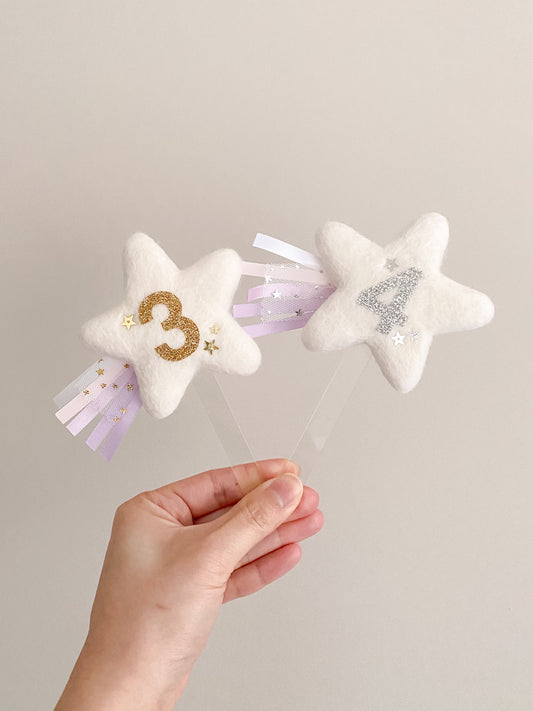 Star shaped cake topper with birthday age and ribbon streams and glitter stars 